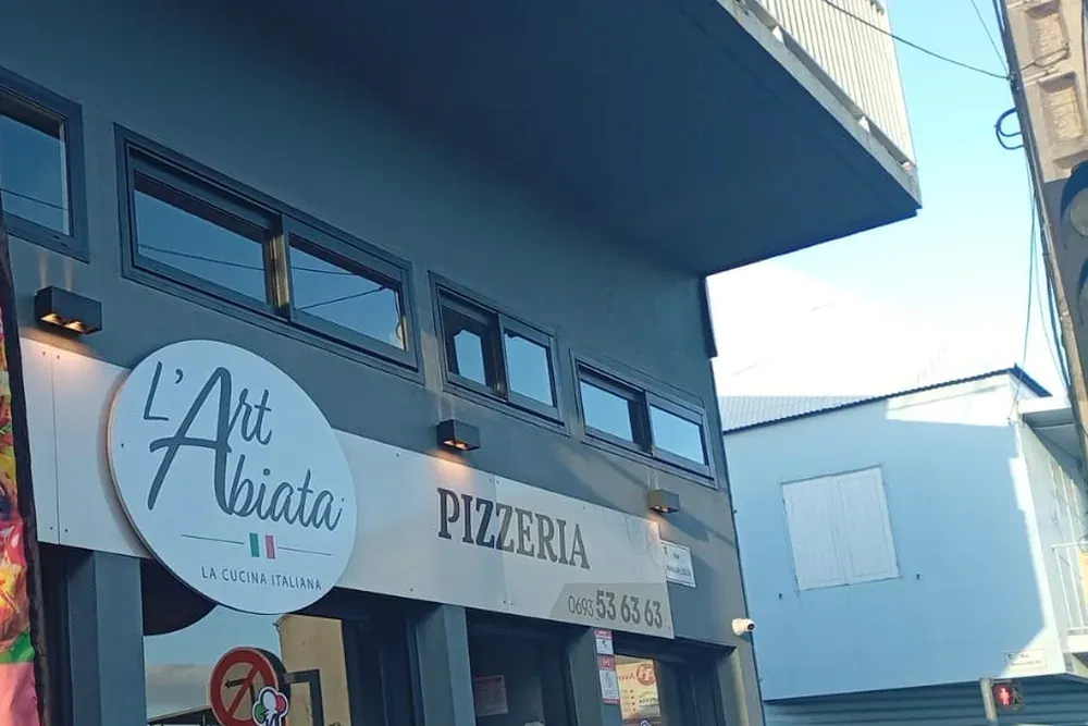 La devanture de L'Art Abiata : enseigne ronde « L'Art Abiata, La Cucina Italiana » et « Pizzeria » sur la façade